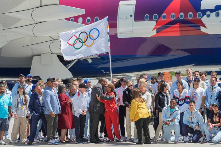 Los Angeles Mayor Karen Bass, hugs Inglewood James Butts, middle, as they pose for a picture wi ...