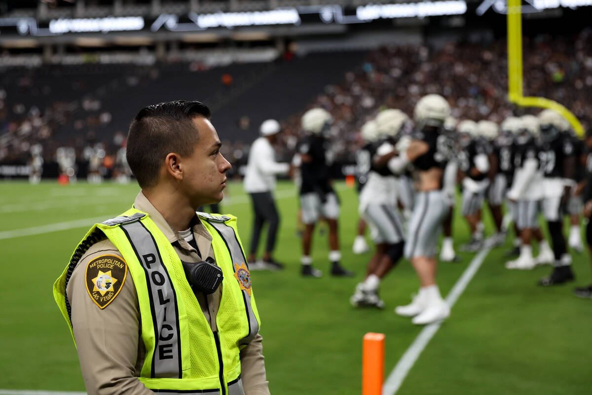 A Metropolitan Police Department officer works during a Raiders NFL football practice at Allegi ...