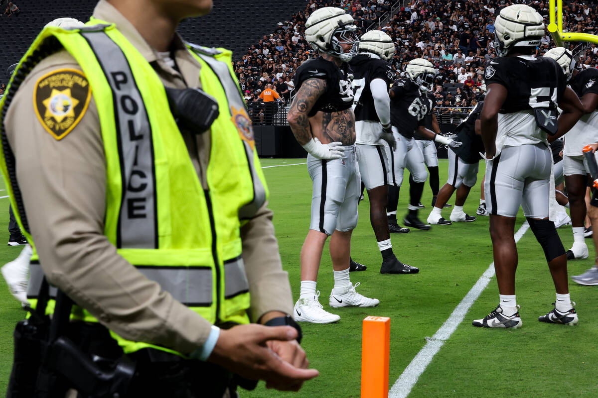 A Metropolitan Police Department officer works during a Raiders NFL football practice at Allegi ...