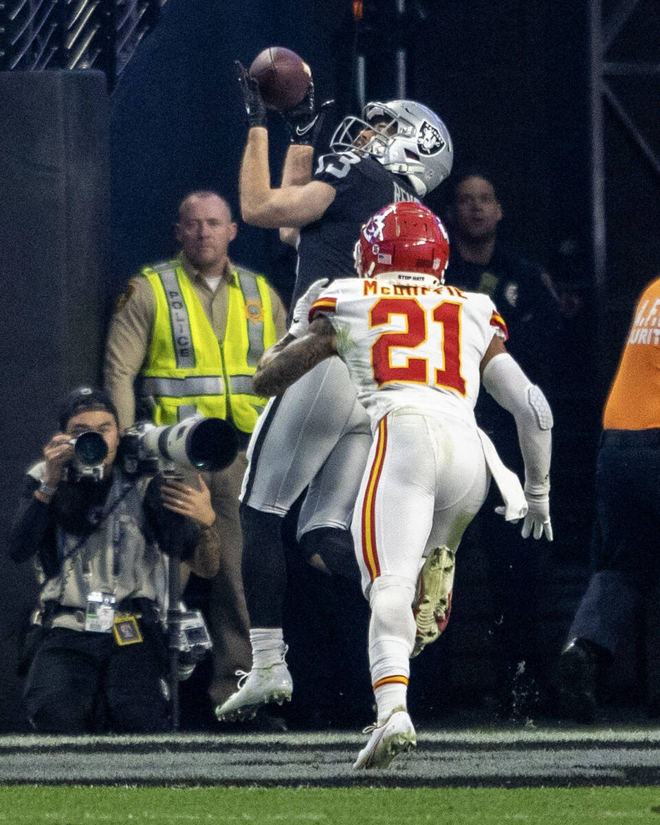 A Metro officer in a yellow vest is seen in the background as Raiders wide receiver Hunter Renf ...