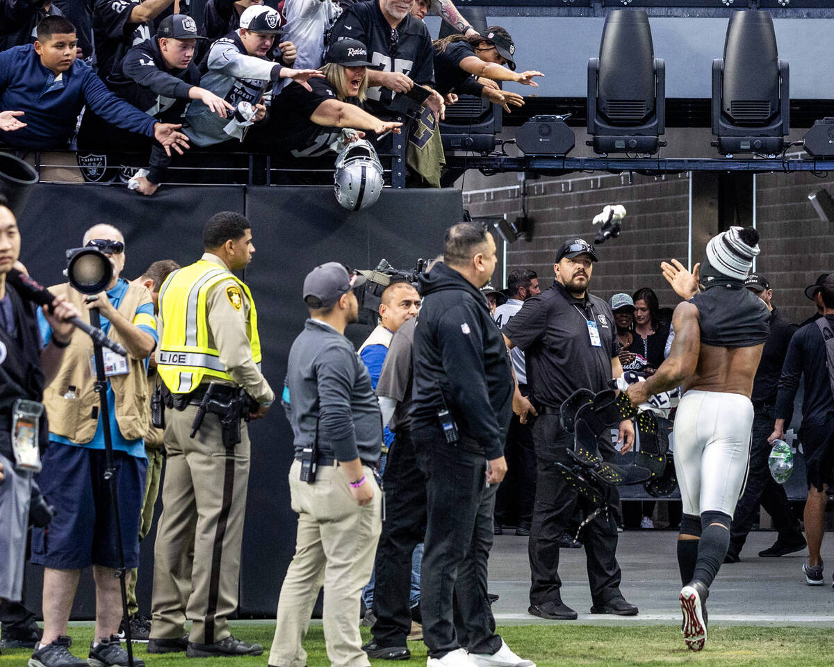 A Metro officer in a yellow vest is seen in the background as Raiders linebacker Denzel Perryma ...