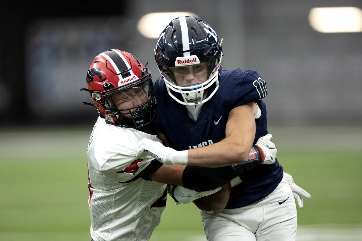 Lake Mead wide receiver Bowe Farmer (11) is pushed out of bounds on the carry by Pershing Count ...