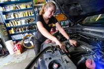 FILE - Elise Lacroix, owner of Stop & Go in Brattleboro, Vt., changes the oil on a vehicle ...