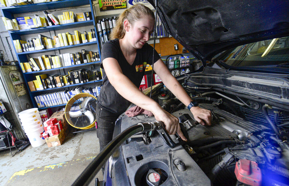 FILE - Elise Lacroix, owner of Stop & Go in Brattleboro, Vt., changes the oil on a vehicle ...