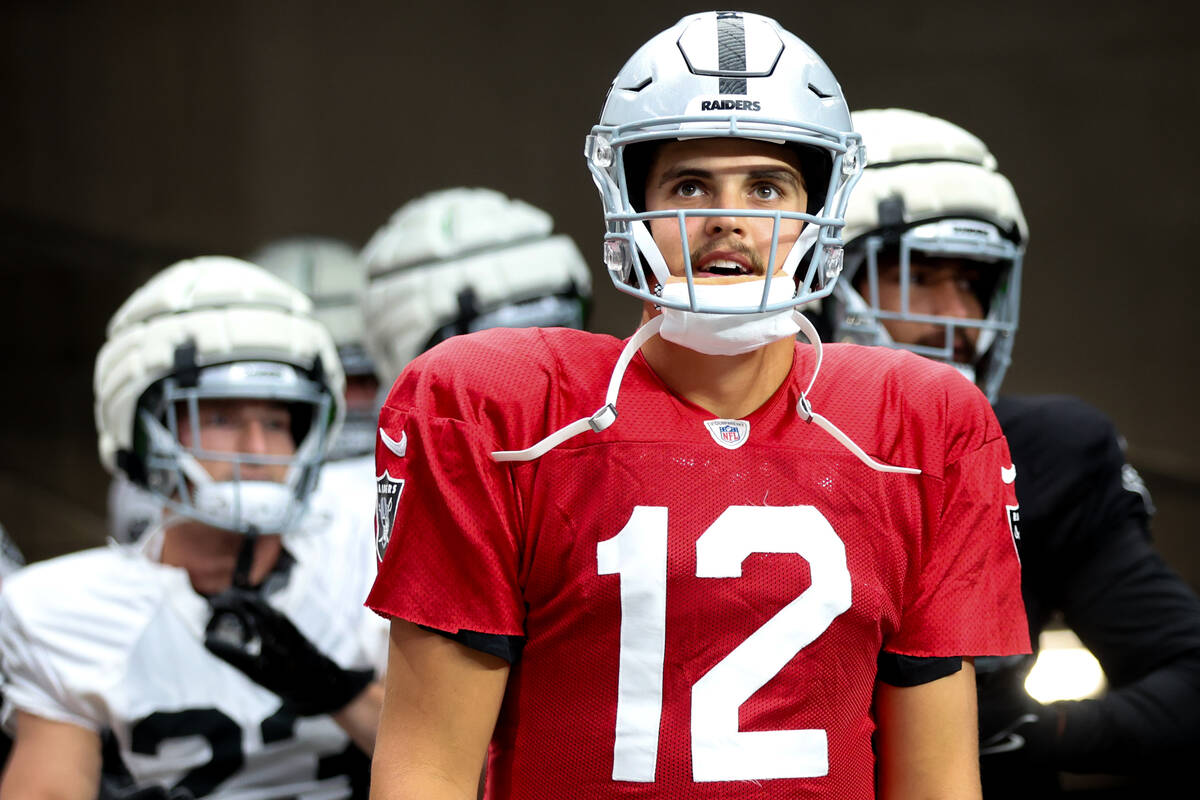 Raiders quarterback Aidan O'Connell (12) takes the field for an NFL football practice at Allegi ...