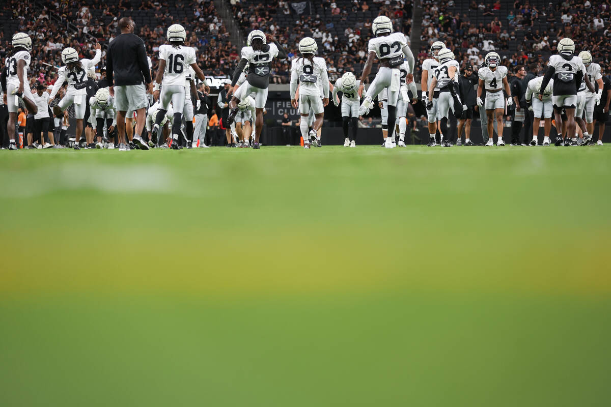 The Raiders stretch during an NFL football practice at Allegiant Stadium on Wednesday, Aug. 14, ...