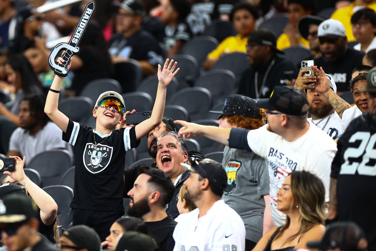 Raiders fans cheer during an NFL football practice at Allegiant Stadium on Wednesday, Aug. 14, ...