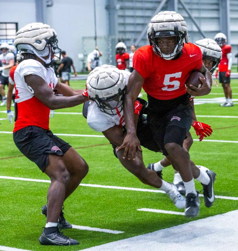 UNLV running back Greg Burrell (5) is driven out of bounds by defensive back Saadite Green Jr. ...