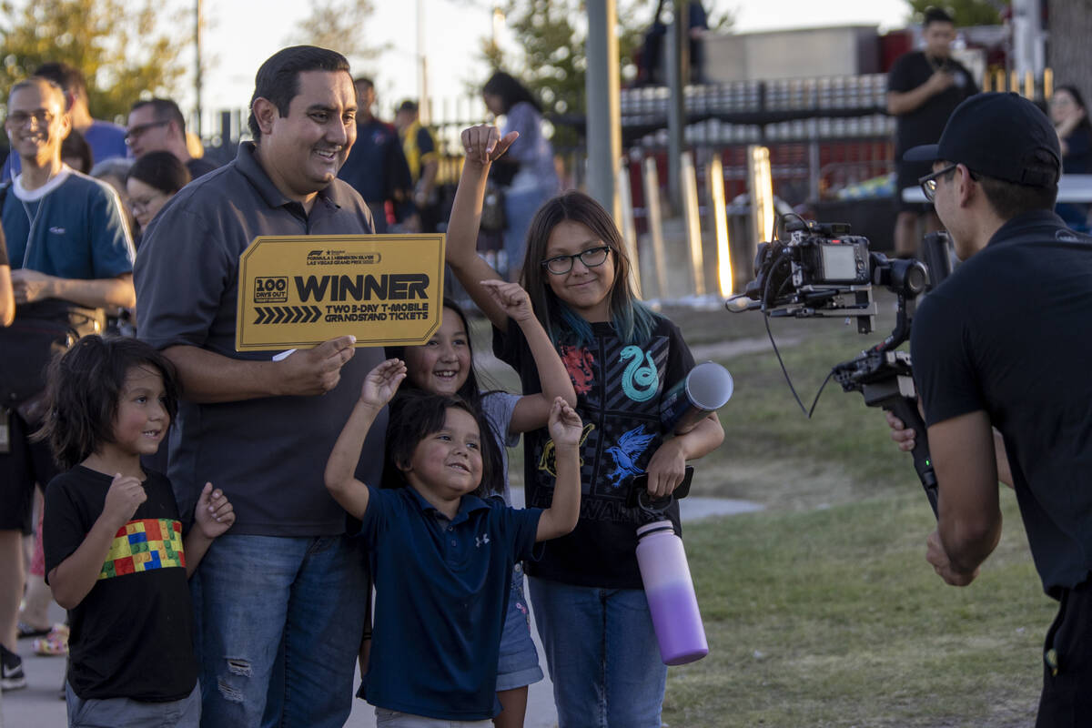 A winner celebrates for a camera during the Las Vegas Grand Prix T-Mobile Grandstand ticket giv ...