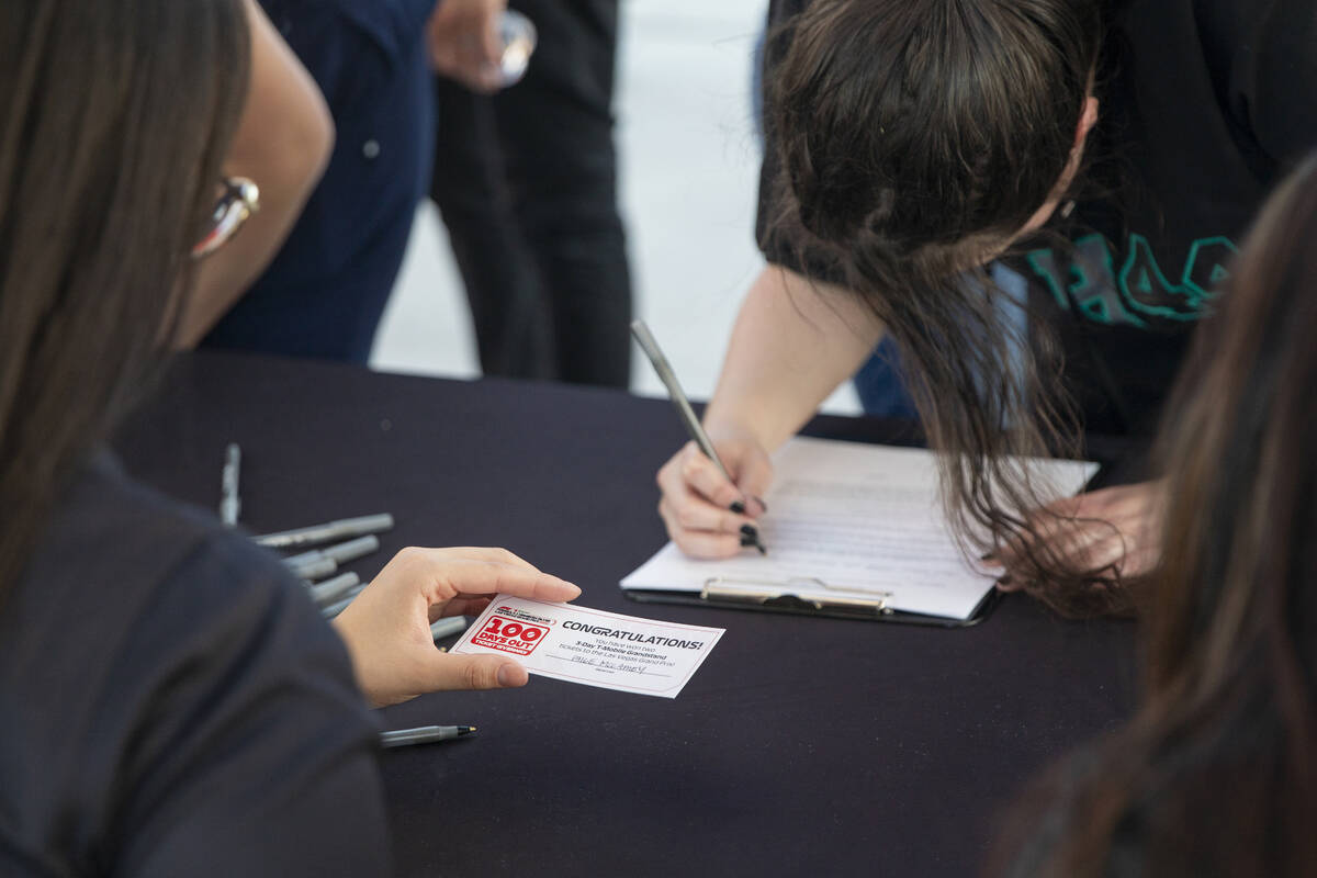 A winner fills out information to receive two free tickets during the Las Vegas Grand Prix T-Mo ...