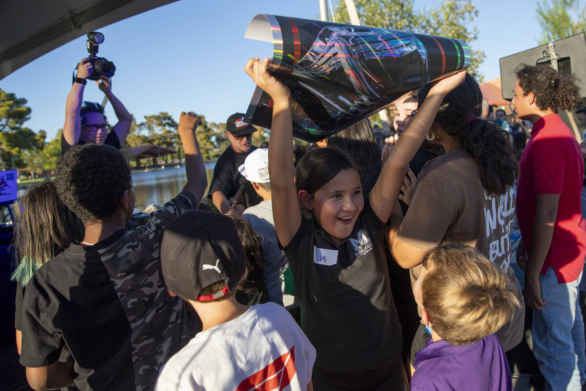 A young fan walks away with a Formula 1 poster during the Las Vegas Grand Prix T-Mobile Grandst ...