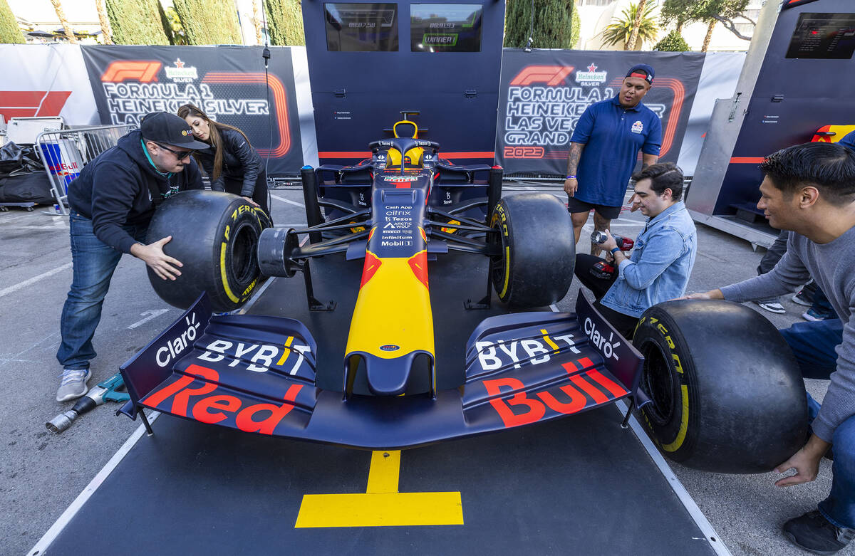 Angel Rodriguez, left, of Las Vegas, competes in a pit stop tire-changing race during the Formu ...