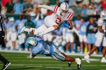 Mississippi quarterback Jaxson Dart (2) carries for a first down over Tulane defensive back DJ ...