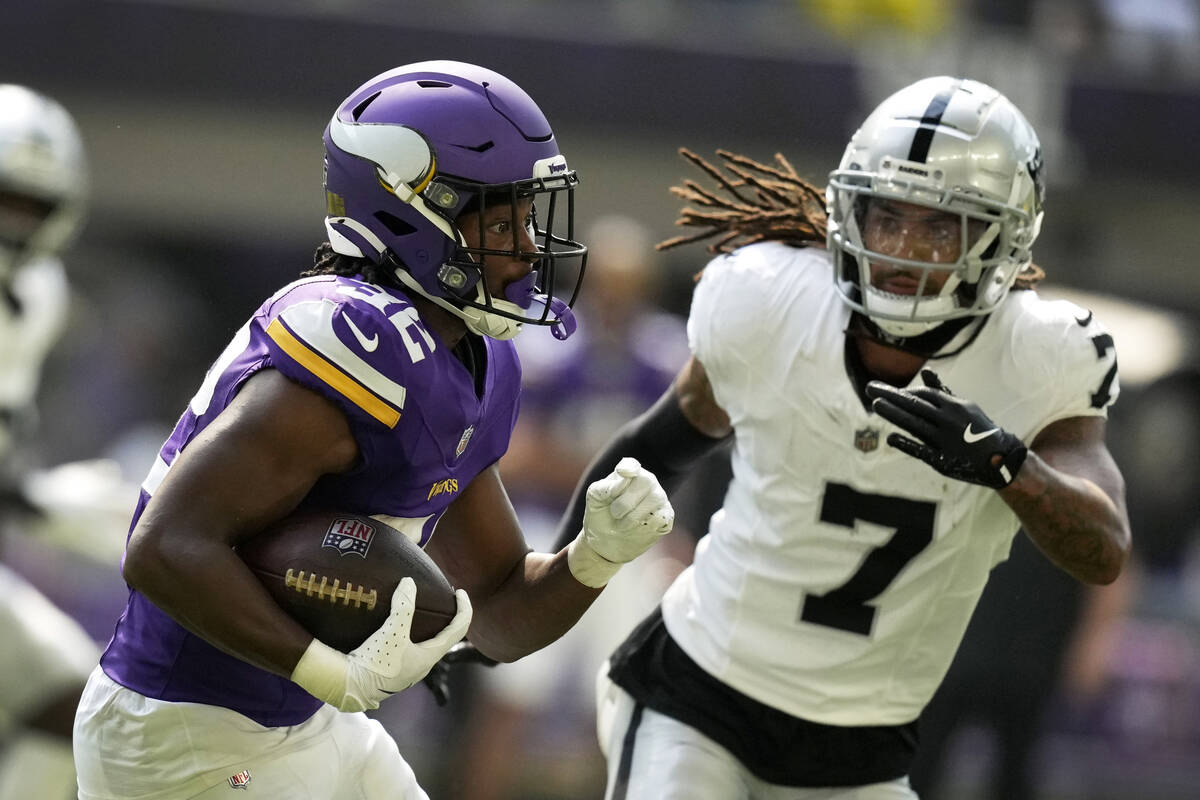 Minnesota Vikings running back Ty Chandler (32) runs from Las Vegas Raiders safety Tre'von Moeh ...