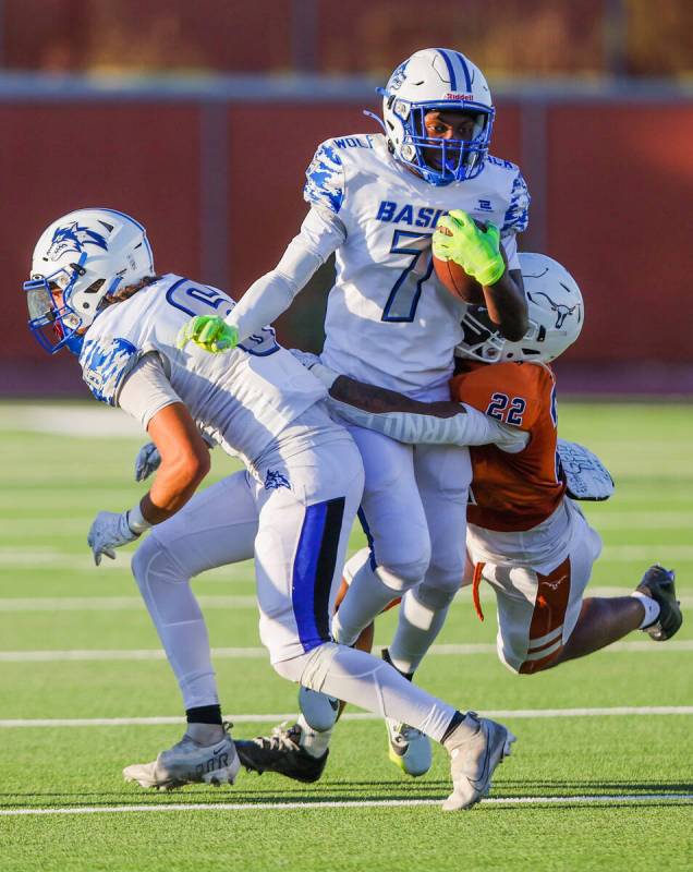 Basic’s Christopher McKenzie (7) keeps hold of the ball as Legacy’s Martel McKenzie (22) gr ...