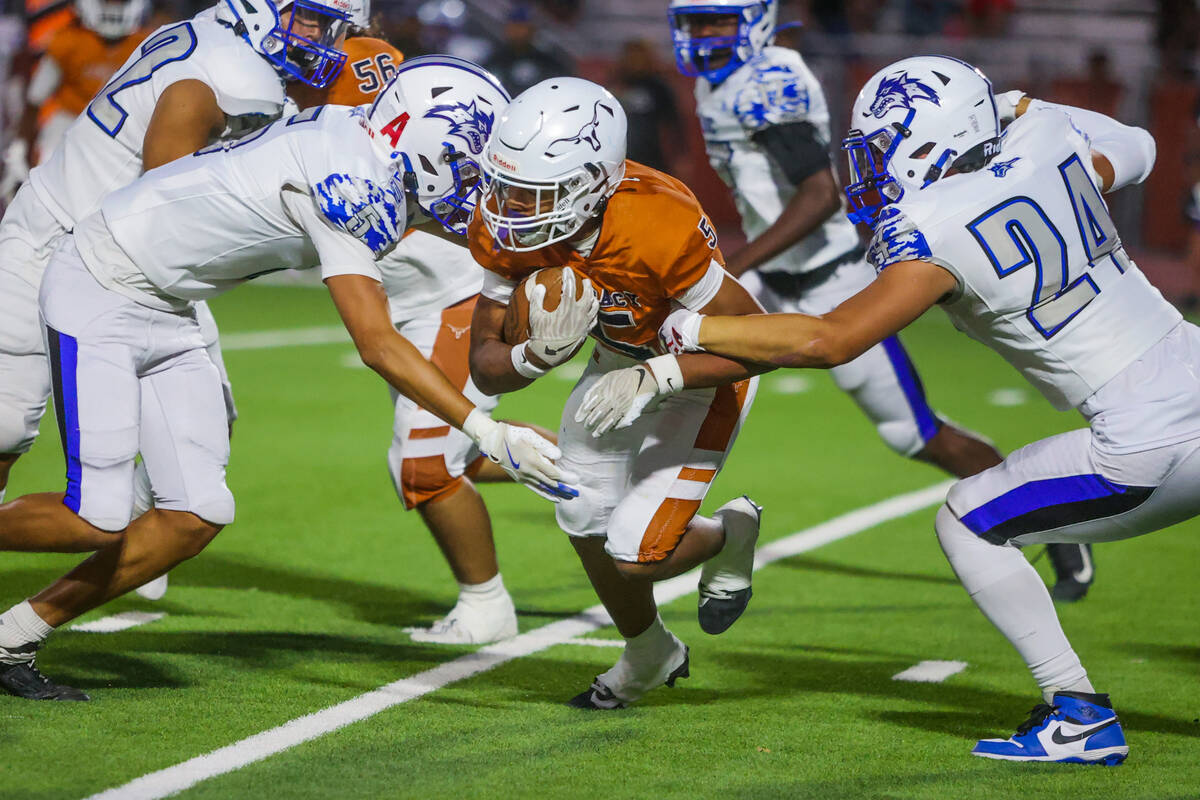 Legacy halfback Zion Henderson looks to evade tacklers during a football game between Legacy an ...