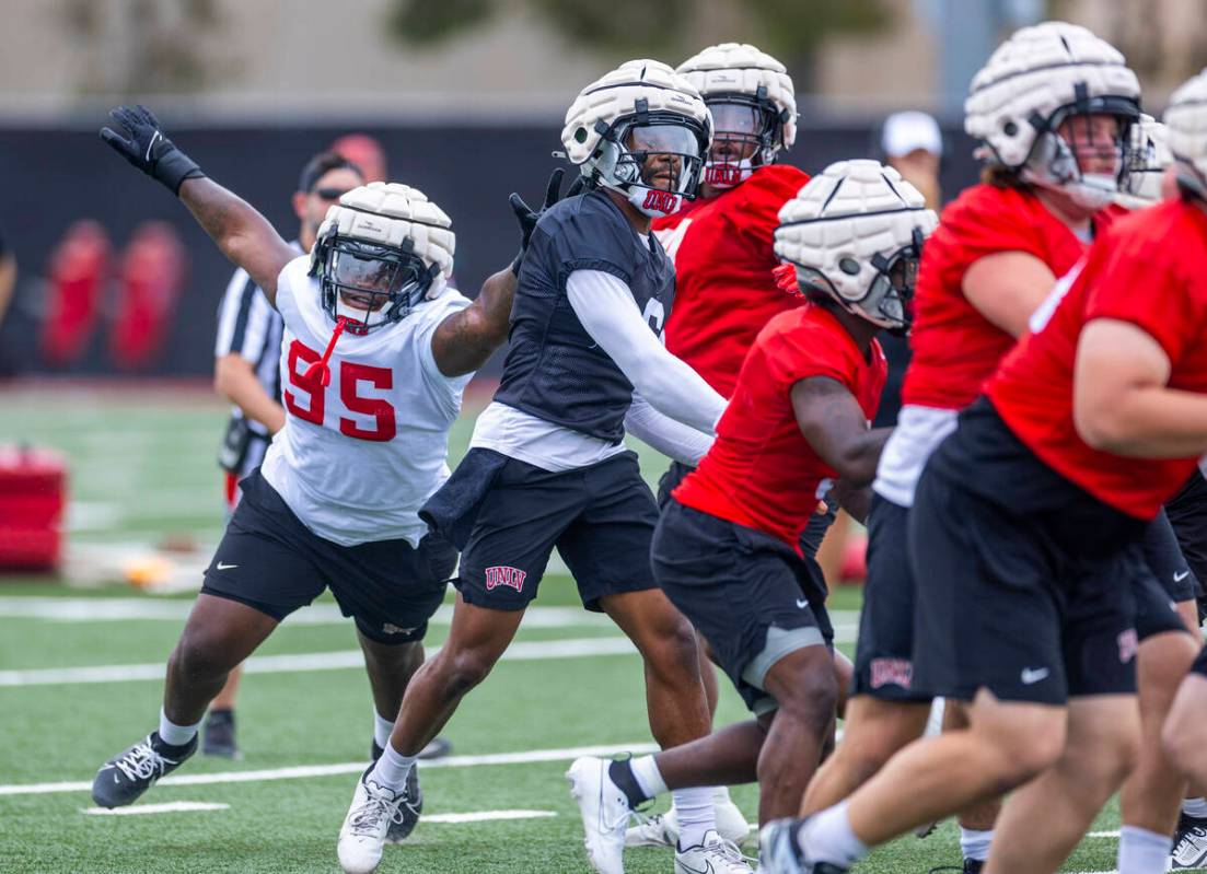 UNLV defensive lineman Alexander Whitmore (95) attempts to stop quarterback Hajj-Malik Williams ...