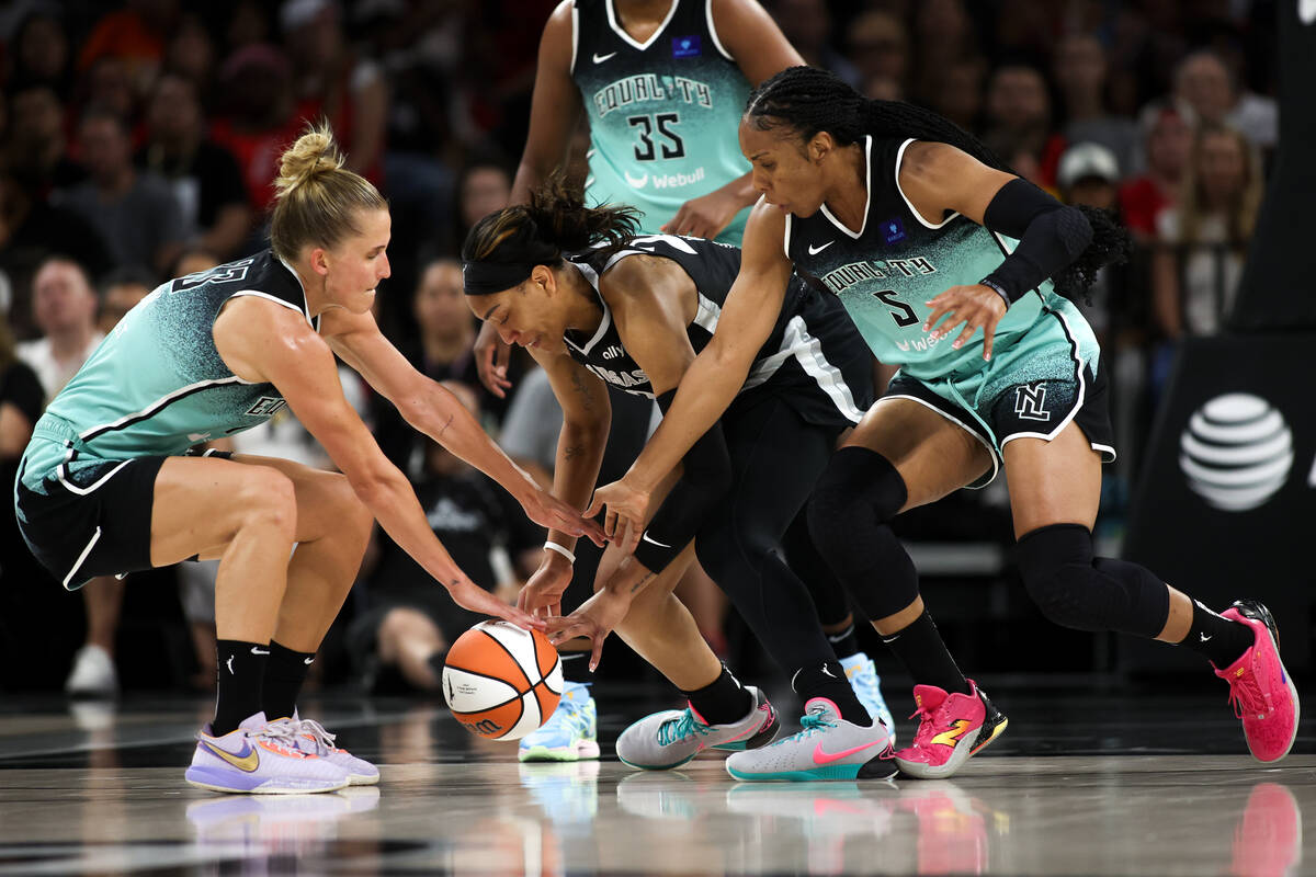 Las Vegas Aces center A'ja Wilson, center, vies for a loose ball against New York Liberty forwa ...