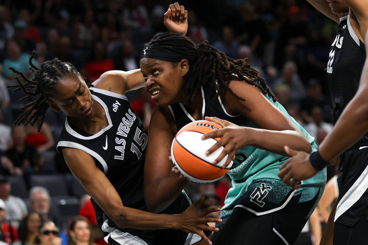 New York Liberty forward Jonquel Jones (35) works toward the hoop while Las Vegas Aces guard Ti ...