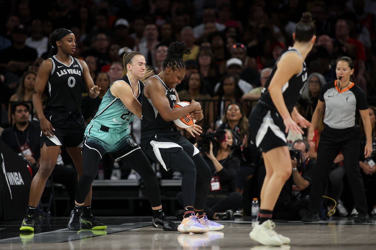 Las Vegas Aces guard Chelsea Gray, center, steals the ball from New York Liberty guard Sabrina ...