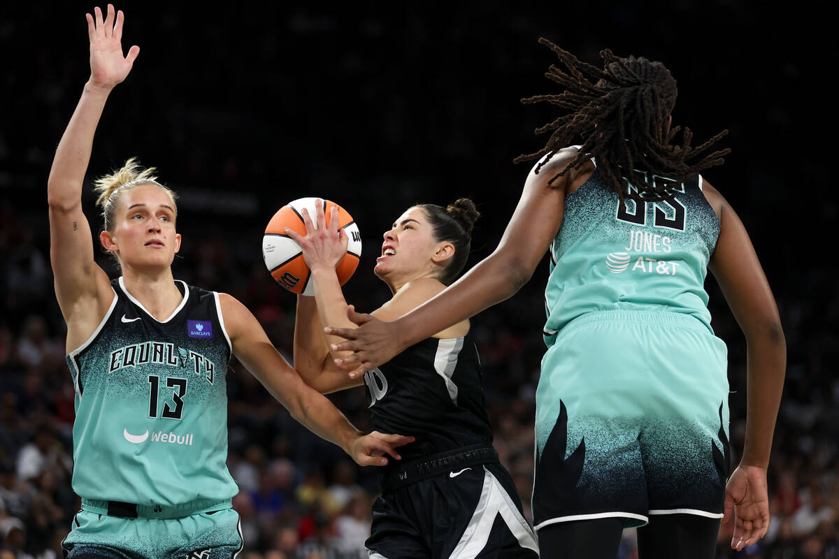 Las Vegas Aces guard Kelsey Plum (10) drives toward the hoop between New York Liberty forward L ...