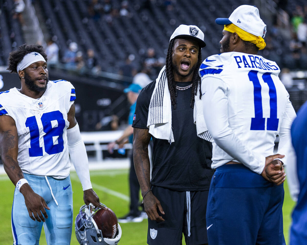 Raiders wide receiver Davante Adams (17) chats with Dallas Cowboys linebacker Micah Parsons (11 ...