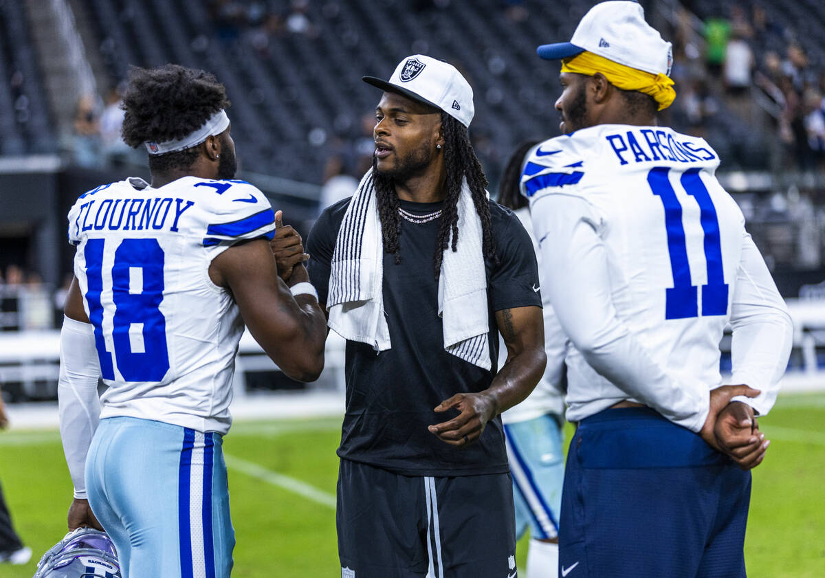 Raiders wide receiver Davante Adams (17) chats with Dallas Cowboys linebacker Micah Parsons (11 ...