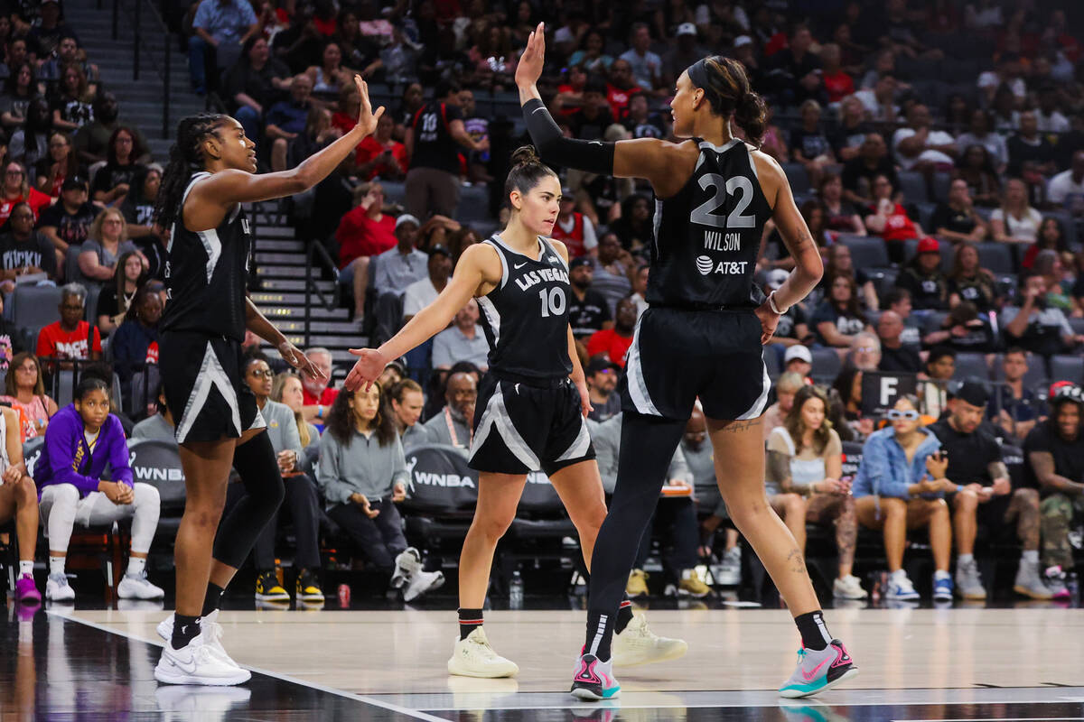 Aces center A'ja Wilson (22) and guard Kelsey Plum (10) high five teammate Tiffany Hayes (15) ...