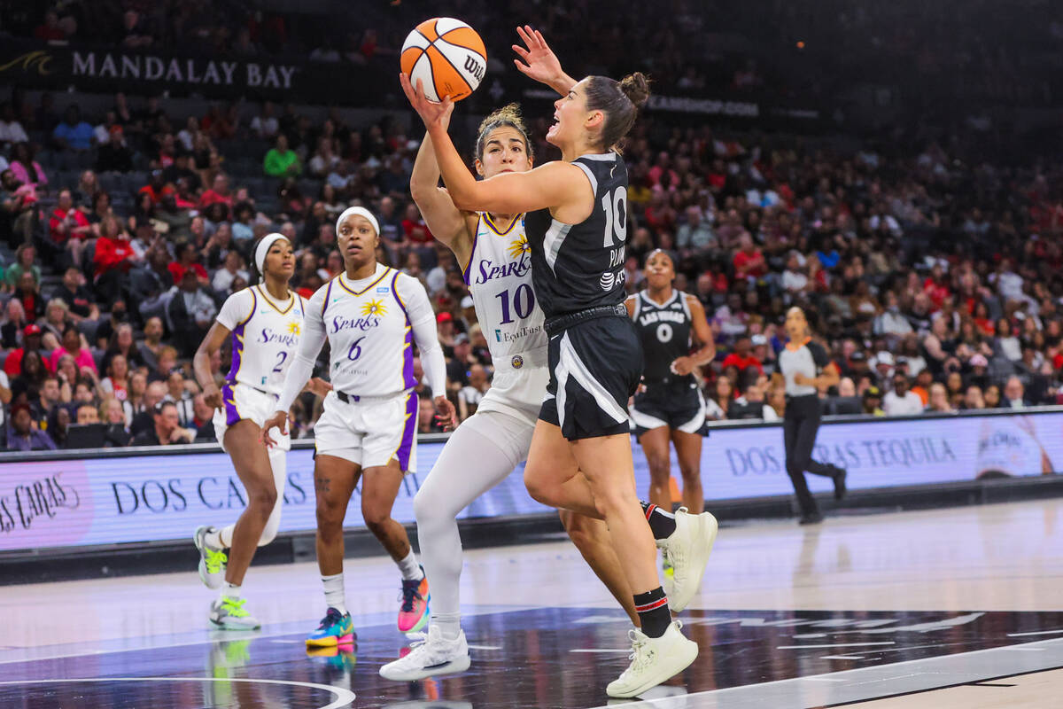 Aces guard Kelsey Plum (10) fights to make a basket as Los Angeles Sparks guard Kia Nurse (10) ...