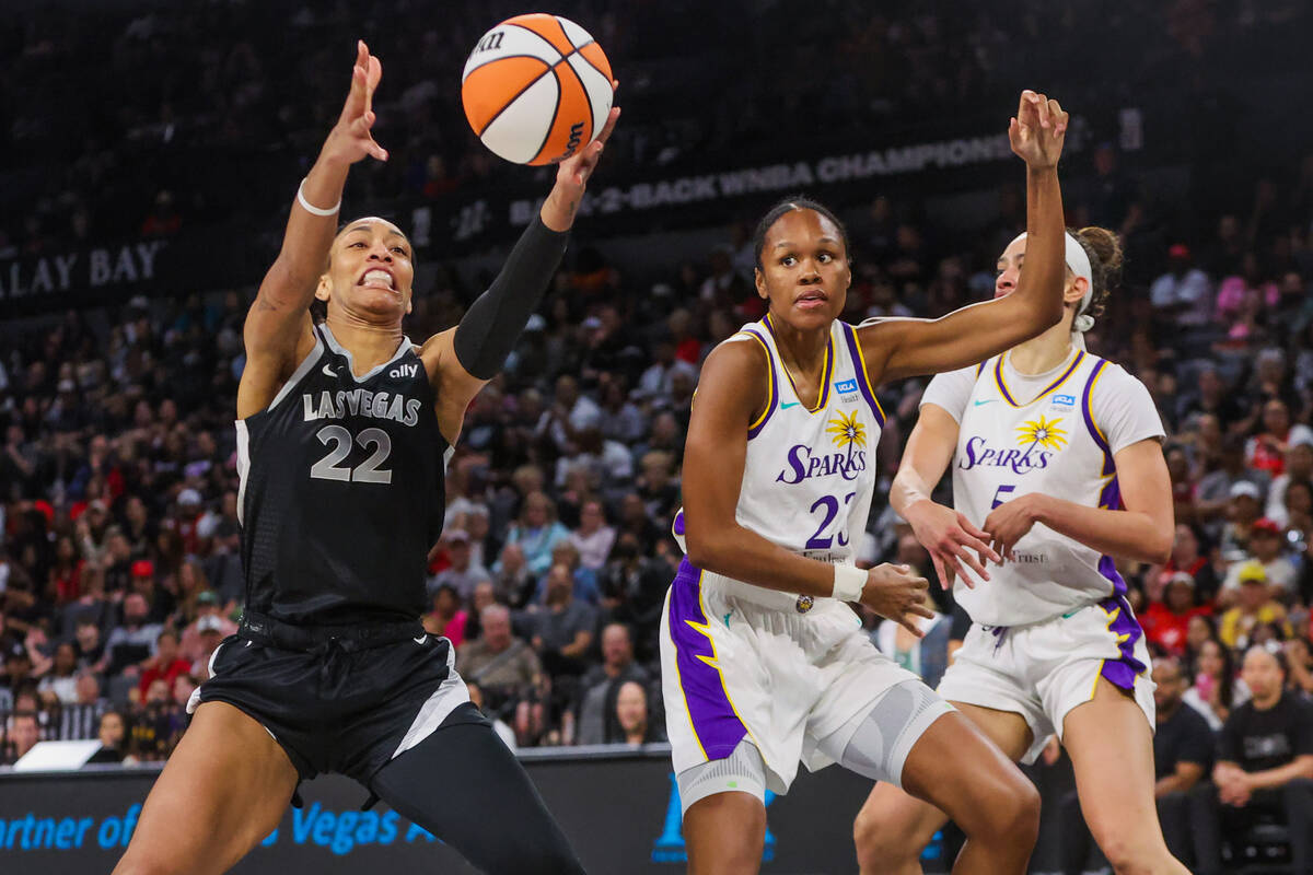 Aces center A'ja Wilson (22) reaches for the ball as Los Angeles Sparks forward Azura Stevens ( ...