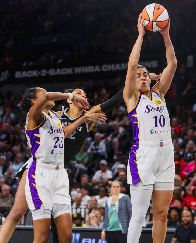 Aces center A'ja Wilson (22) reaches for the ball as Los Angeles Sparks guard Kia Nurse (10) co ...