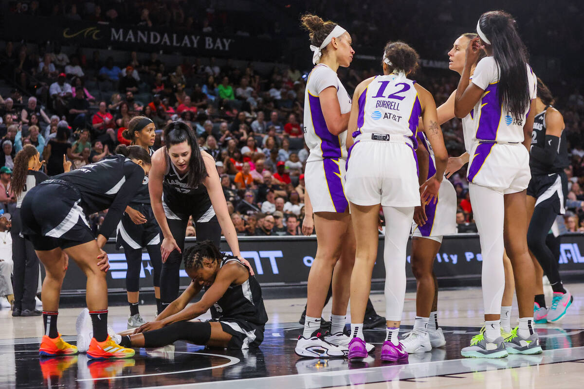 Aces teammates Alysha Clark (7) and center Megan Gustafson (17) check on Aces guard Tiffany Hay ...