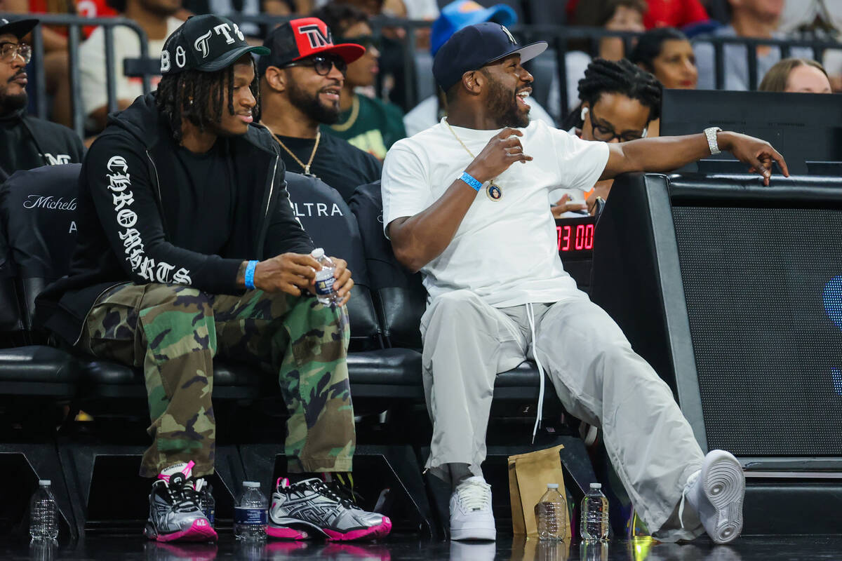 Professional boxer Floyd Mayweather, right, watches a WNBA basketball game between the Aces and ...