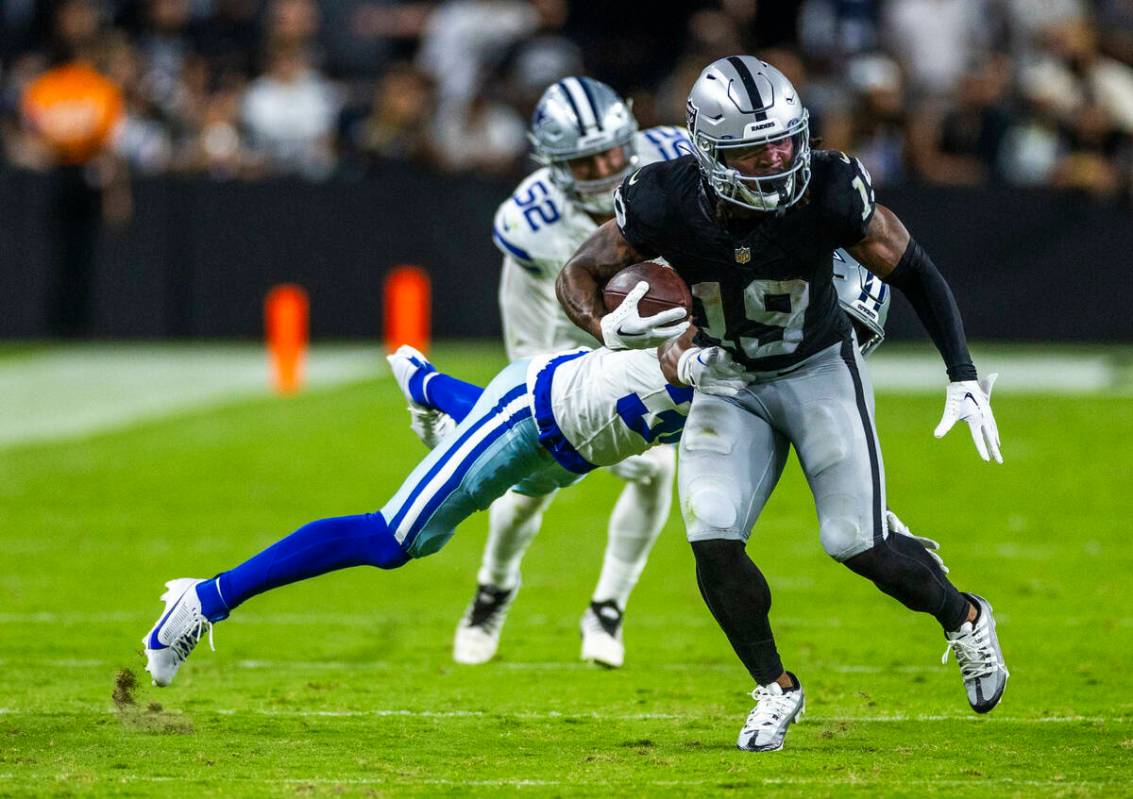 Raiders wide receiver DJ Turner (19) breaks a tackle attempt by the Dallas Cowboys defense duri ...