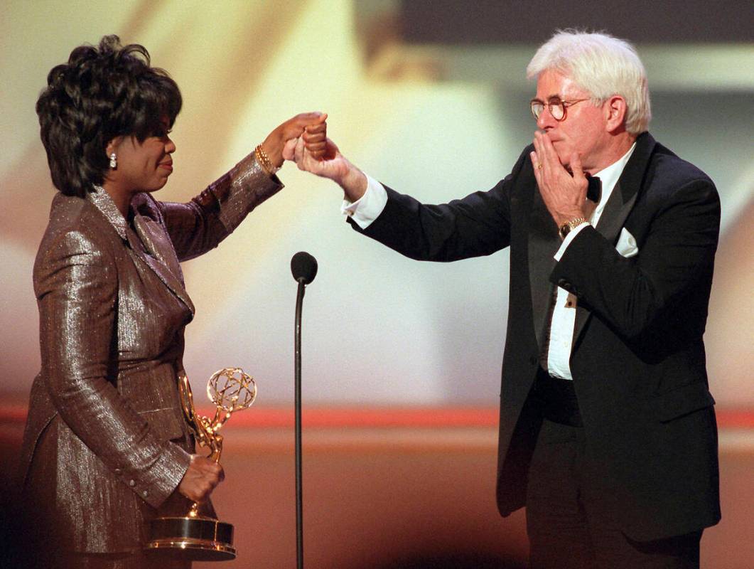 FILE - Phil Donahue blows a kiss to Oprah Winfrey as she presents him with a Lifetime Achieveme ...