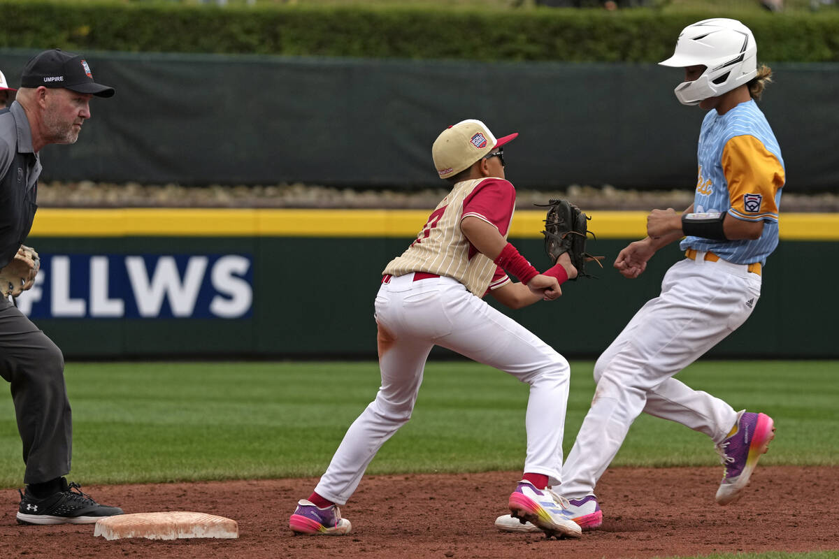 Henderson, Nev.'s Russell McGee, center, tags out Wailuku, Hawaii's Kamalei Leynes-Santos, righ ...