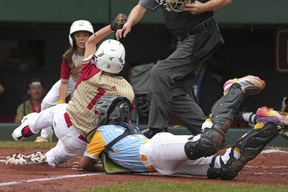 Henderson, Nev.'s Dominic Laino, front left, slides around Wailuku, Hawaii's Matthew Yong, righ ...