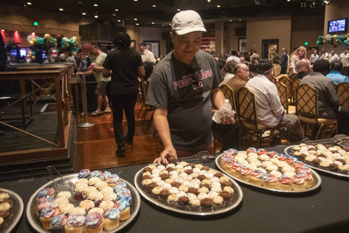 Tuan Nguyen, a staff member of over 25 years, reaches for a cupcake during Boulder Station&#x20 ...