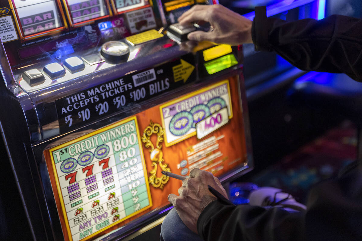 A gambler smokes a cigarette while trying his luck at The Plaza on Thursday, March 2, 2023, in ...