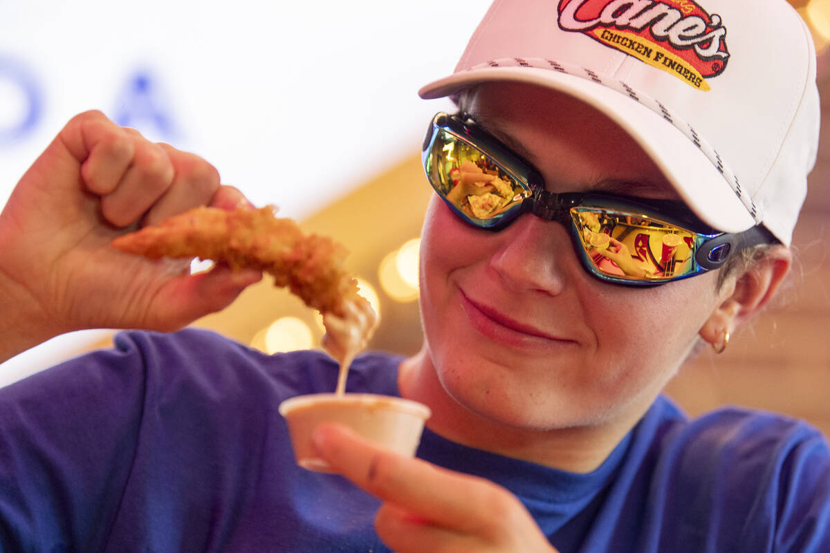 Olympic medalist Katie Grimes dunks a chicken finger in sauce during a promotional homecoming & ...