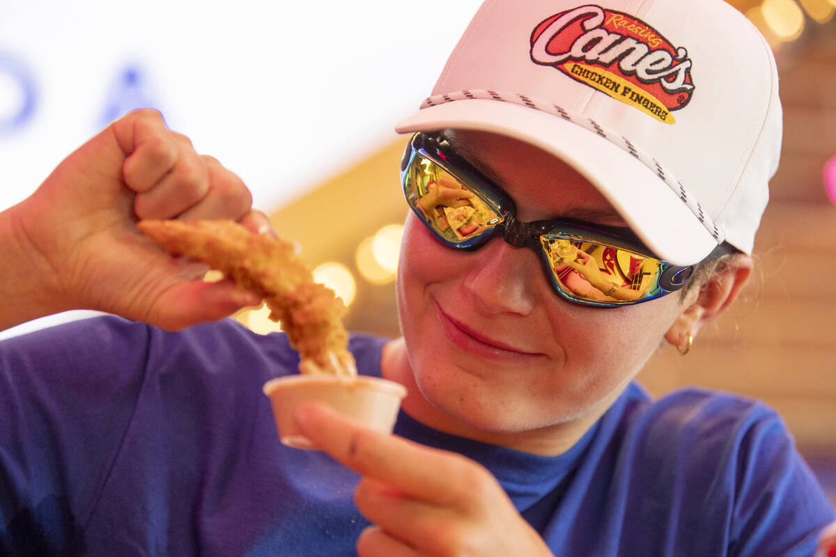 Olympic medalist Katie Grimes dunks a chicken finger in sauce during a promotional homecoming & ...