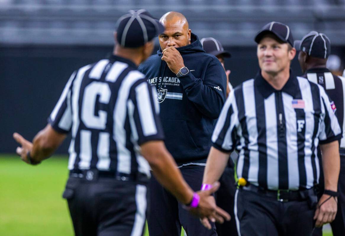 Raiders head coach Antonio Pierce talks looks on as officials joke around during an open practi ...