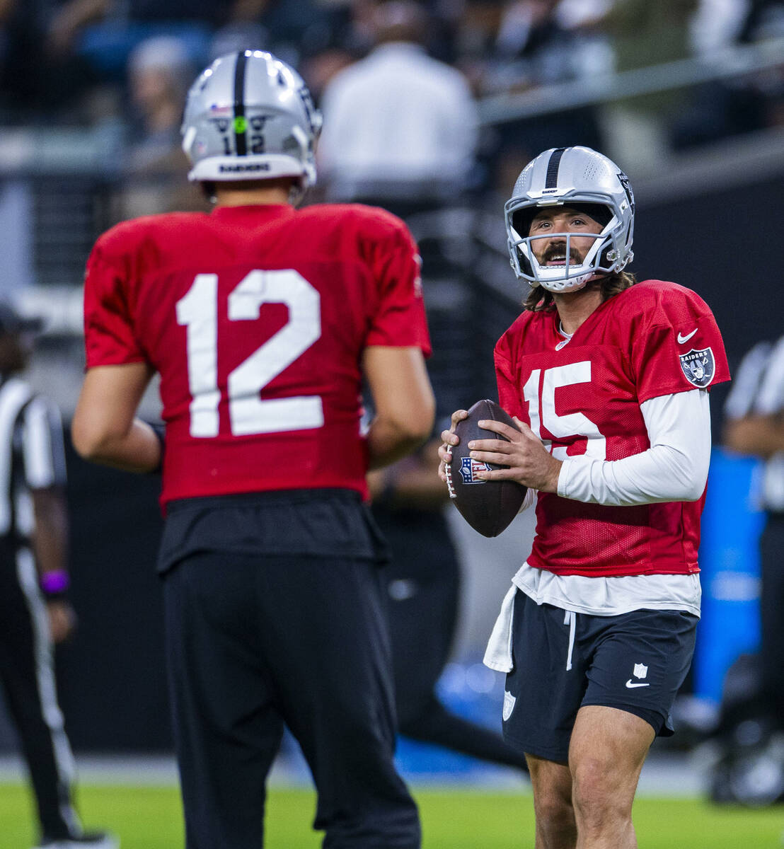 Raiders quarterback Gardner Minshew (15) chats with quarterback Aidan O'Connell (12) during an ...