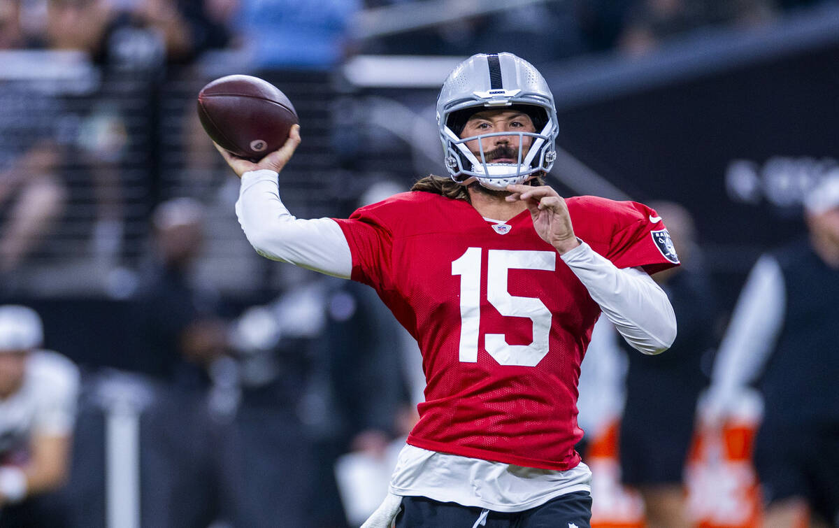 Raiders quarterback Gardner Minshew (15) looks to a receiver on a throw during an open practice ...