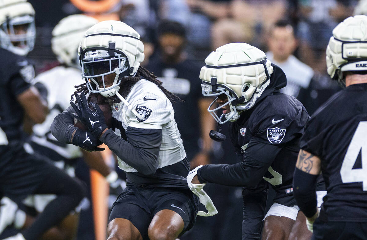 Raiders wide receiver Davante Adams (17) secures a catch against cornerback Jakorian Bennett (0 ...