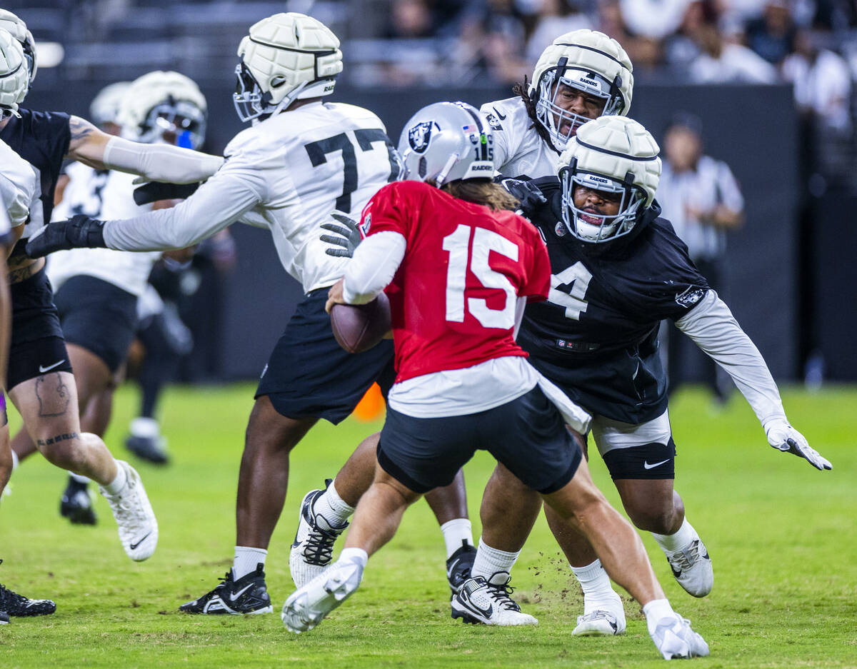 Raiders quarterback Gardner Minshew (15) looks to evade a strong rush by defensive tackle Chris ...