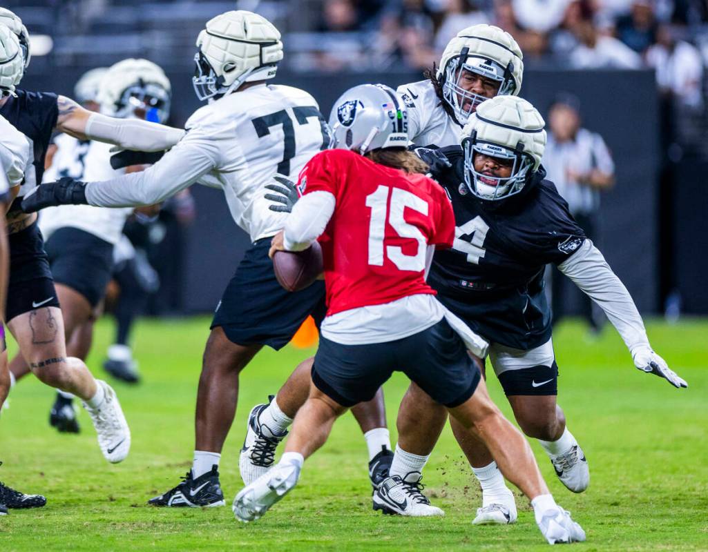 Raiders quarterback Gardner Minshew (15) looks to evade a strong rush by defensive tackle Chris ...