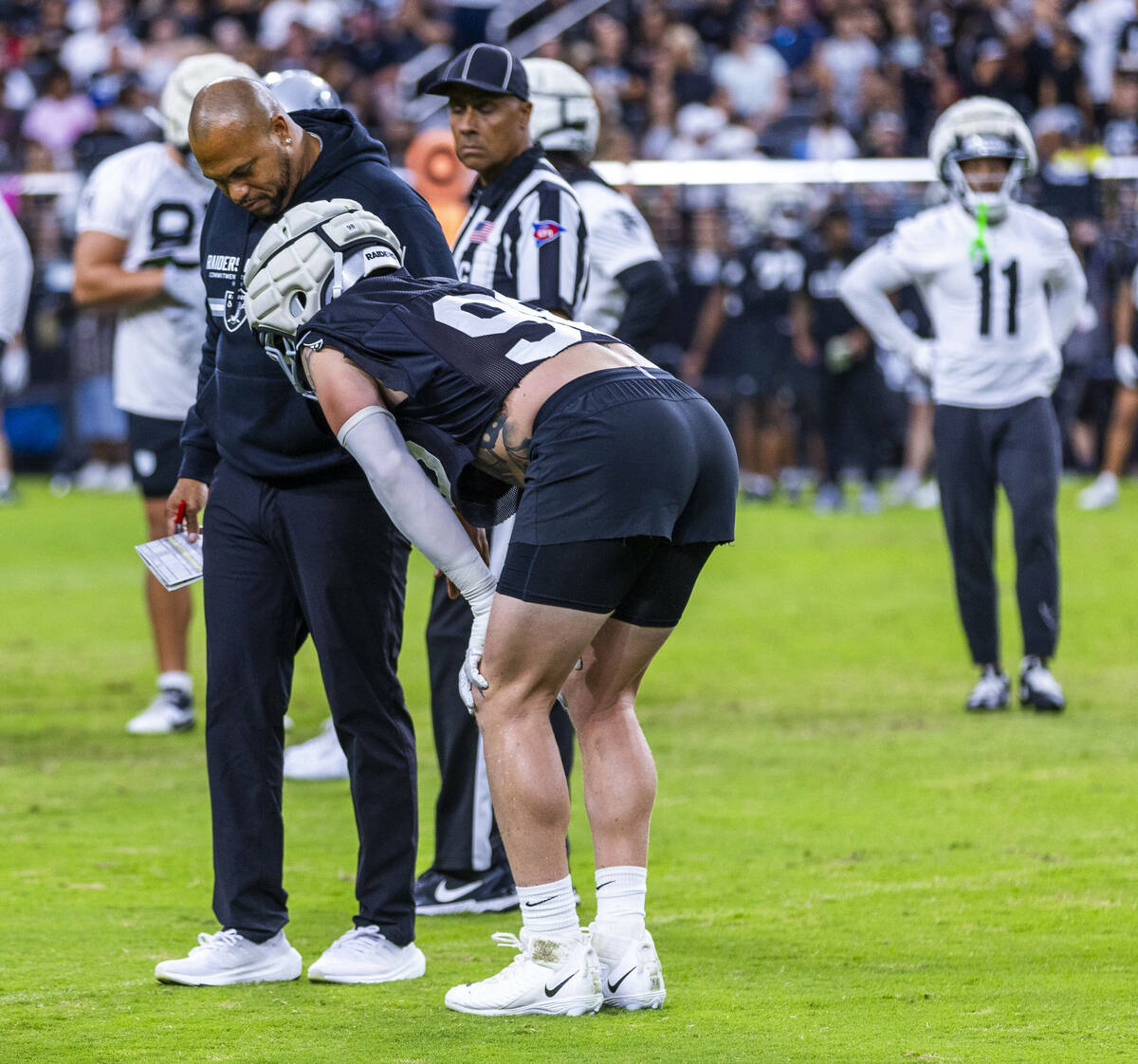 Raiders head coach Antonio Pierce looks to see if defensive end Maxx Crosby (98) is okay after ...