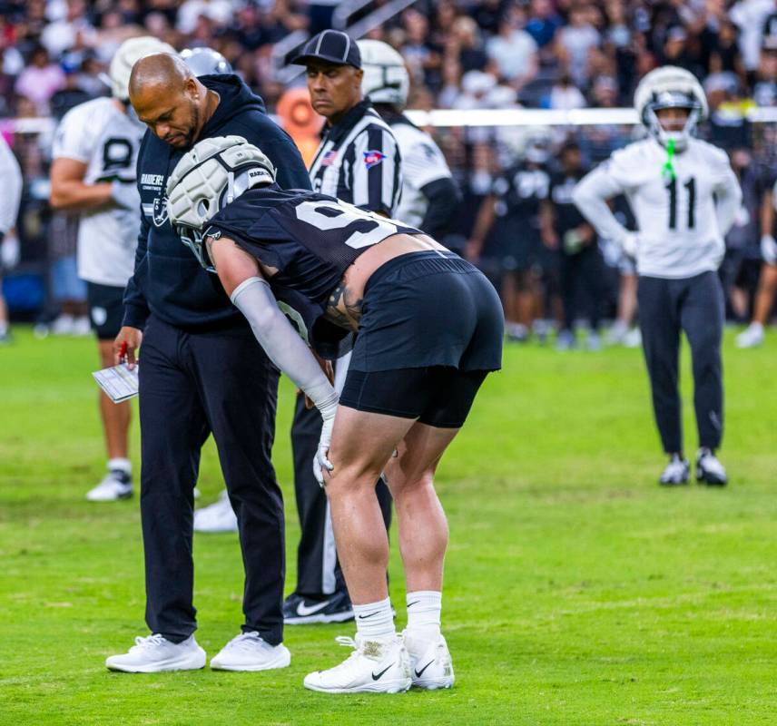 Raiders head coach Antonio Pierce looks to see if defensive end Maxx Crosby (98) is okay after ...