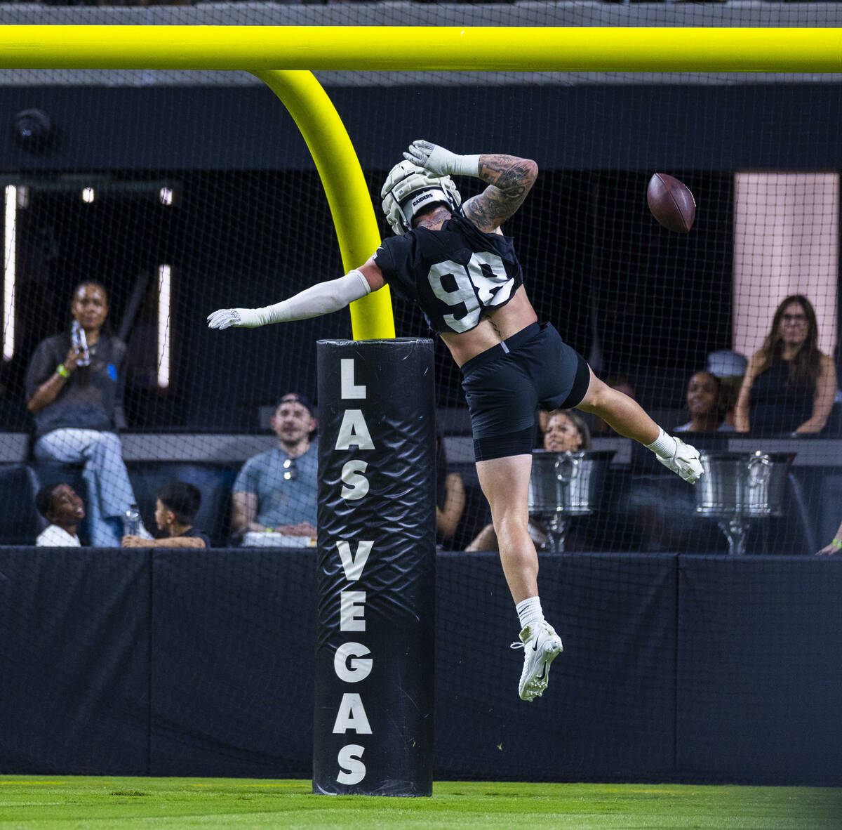 Raiders defensive end Maxx Crosby (98) dunks the ball over the crossbar on a score after an int ...